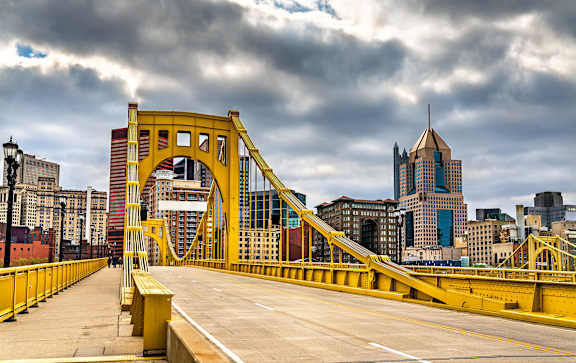 A yellow bridge with a person walking on it.