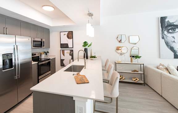 A modern kitchen with a white island and stainless steel appliances.