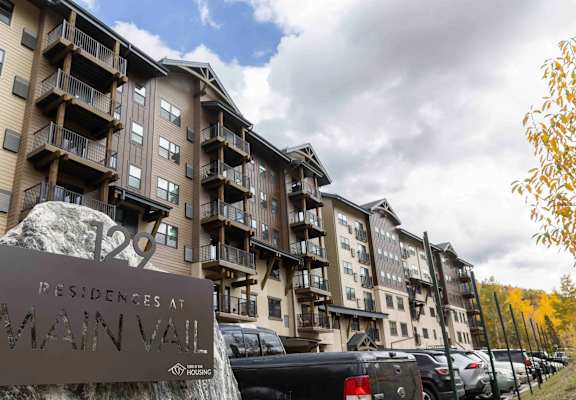 A large apartment complex named "Main Vail" is shown with cars parked in front.