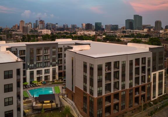 an aerial view of a building with a pool and a city in the background at Abberly Foundry Apartment Homes, Nashville, 37203