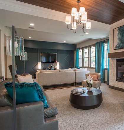 A modern living room with a grey sofa and a fireplace.