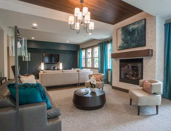 A modern living room with a grey sofa and a fireplace.