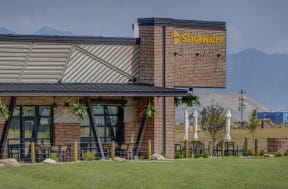 the front of a restaurant with mountains in the background