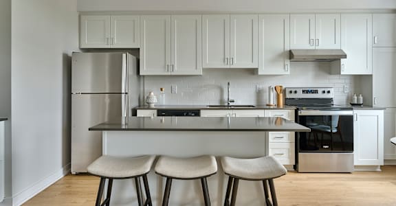 a kitchen with white cabinets and a island with three stools