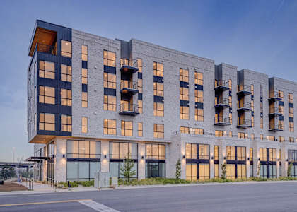 A modern multi-story building with balconies and large windows.
