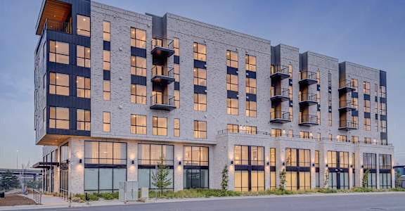 A modern multi-story building with balconies and large windows.