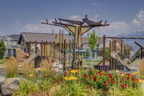 a playground with slides and flowers in a garden