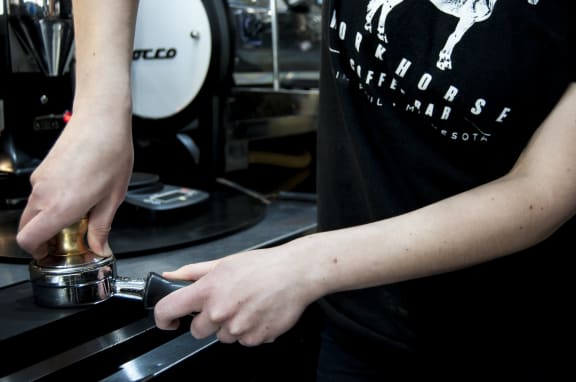 a bartender pours a drink into a cocktail shaker