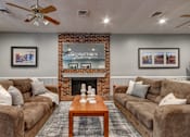Thumbnail 11 of 26 - A living room with a brick fireplace and two couches.