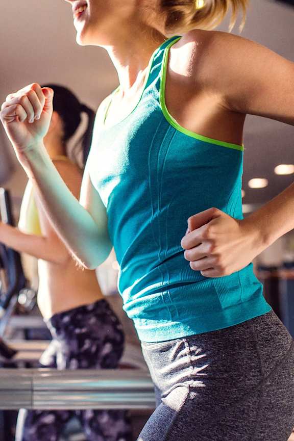 a woman running on a treadmill in a gym