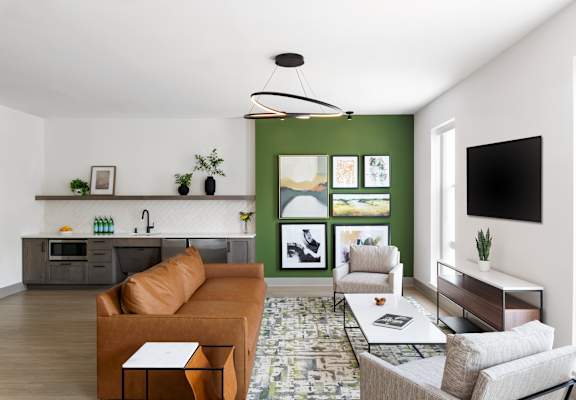 A living room with a brown couch and a green accent wall.
