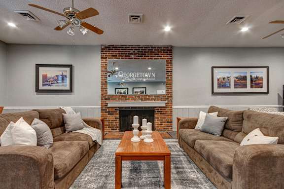 A living room with a brick fireplace and two couches.