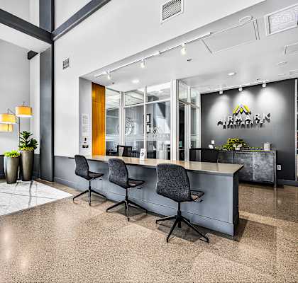 A modern office lobby with a reception desk and chairs.