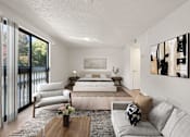 Thumbnail 3 of 29 - A modern bedroom with a large bed and a couch. at AVIA Lofts on Parkway, Vancouver