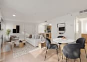 Thumbnail 4 of 29 - A modern living room with a white couch, a coffee table, and a dining table with chairs. at AVIA Lofts on Parkway, Vancouver Washington