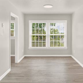 an empty room with white walls and a window