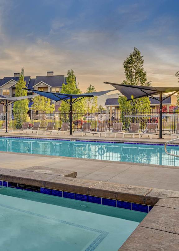 A large outdoor swimming pool with a diving board and lounge chairs.