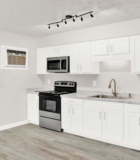 a kitchen with white cabinets and stainless steel appliances and a refrigerator