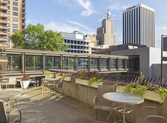 a roof terrace with tables and chairs and a view of the city  at Mears Park Place, St. Paul, Minnesota