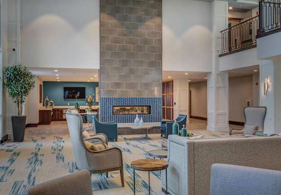 A living room with a fireplace and a blue chair.