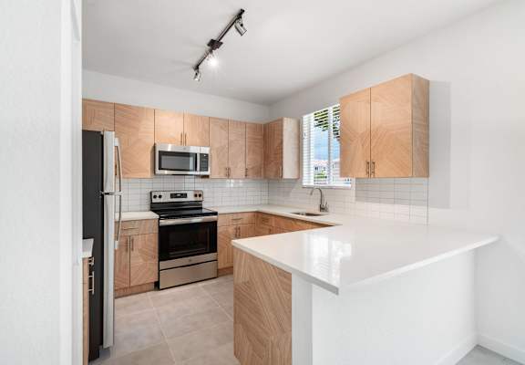 a kitchen with white countertops and wooden cabinets