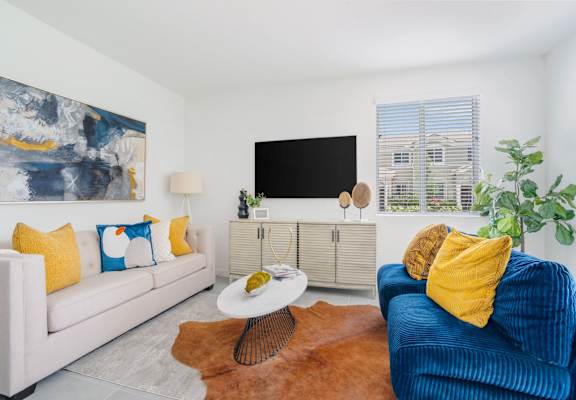 two couches and a coffee table in a living room with a tv on the wall