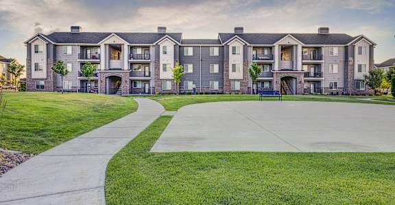 A large apartment complex with a walkway in front.