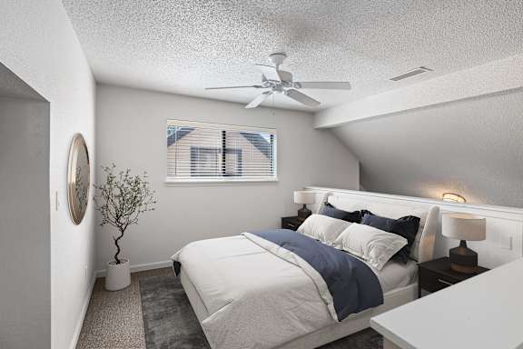 A bedroom with a bed, nightstand, and a plant.