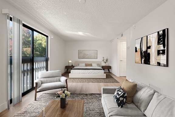 A modern bedroom with a large bed and a couch. at AVIA Lofts on Parkway, Vancouver