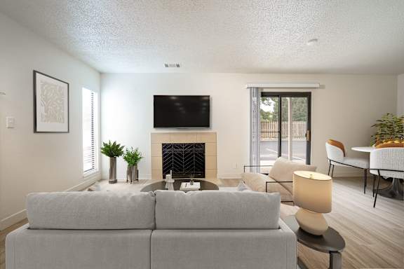 A living room with a grey couch, a fireplace, and a television.