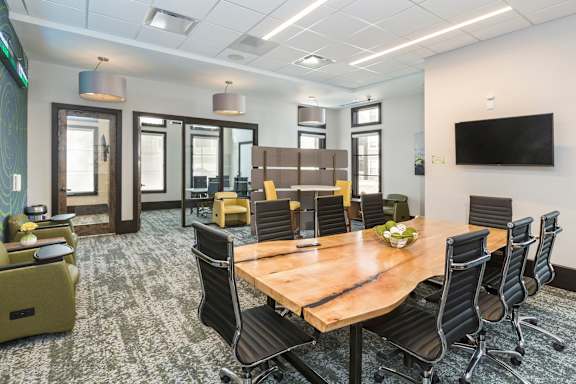 A conference room with a long table surrounded by chairs.