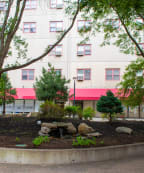 a park with trees and rocks in front of a building