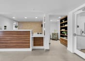 Thumbnail 24 of 47 - a reception area with a wooden reception desk and a door