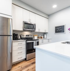a kitchen with white cabinetry and stainless steel appliances