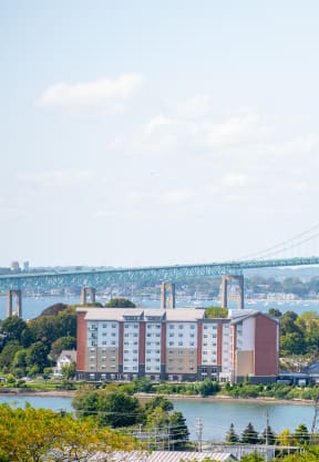 a view of the bridge over the water and a city with buildings and a river