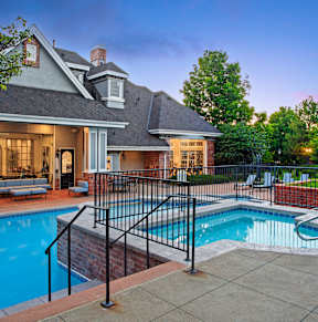 A large house with a pool in front.