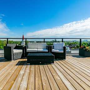 A wooden deck with a table and chairs overlooking a landscape.