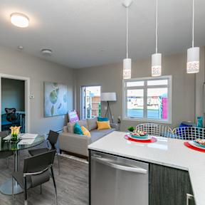 A modern kitchen with a glass table and chairs.