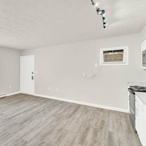 an empty living room with white walls and a window