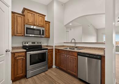 A kitchen with wooden cabinets and black appliances. at Eagles Landing, Ammon, ID, 83406