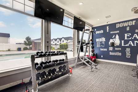 A woman is doing sit-ups on a mat in a bright room. at Eagles Landing, Ammon, ID, 83406