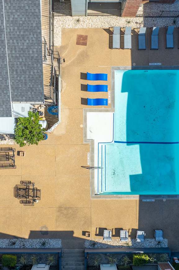 A swimming pool with a blue cover and a table and chairs around it.