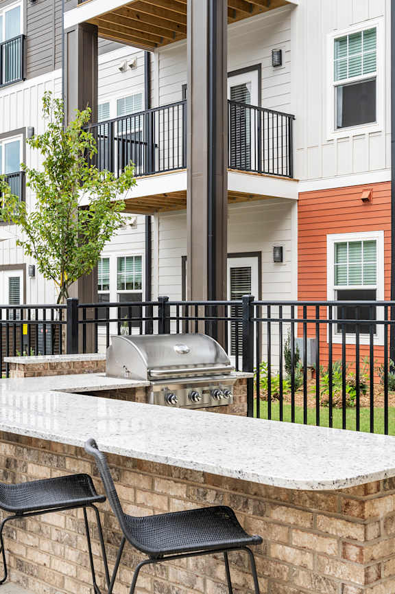 A patio with a bar and chairs in front of a building.