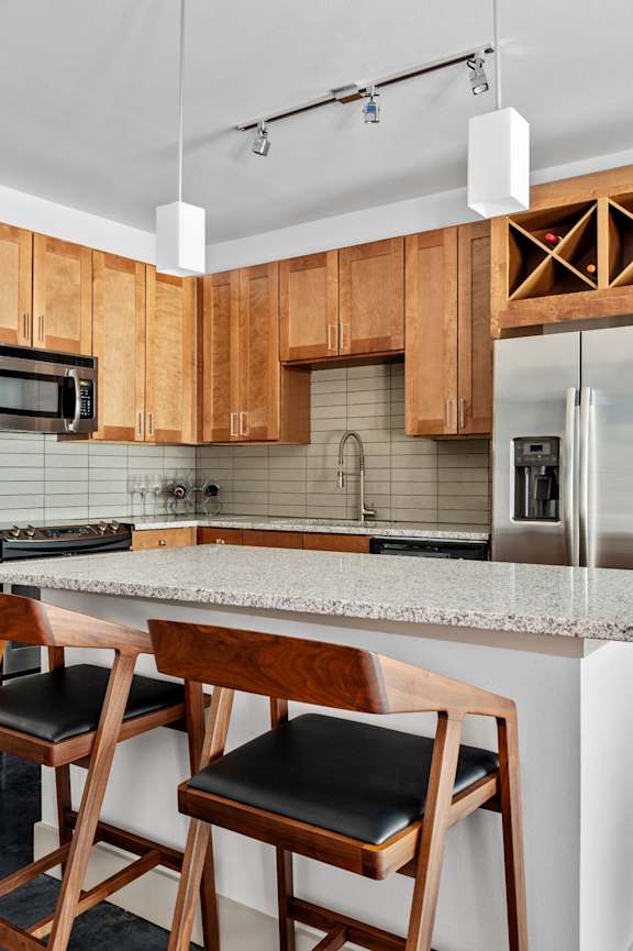 A kitchen with wooden cabinets and a marble countertop.