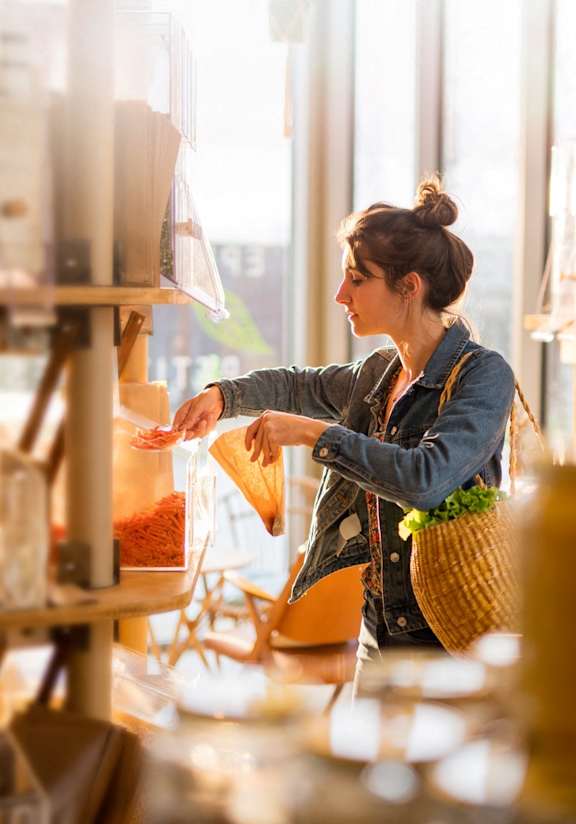 A woman is shopping in a store with a variety of items on display.