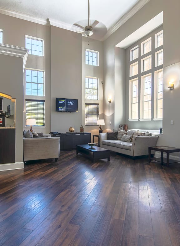 a living room with hardwood floors and large windows