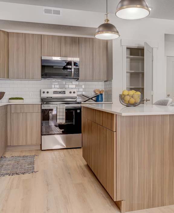 A modern kitchen with wooden cabinets and a white island.