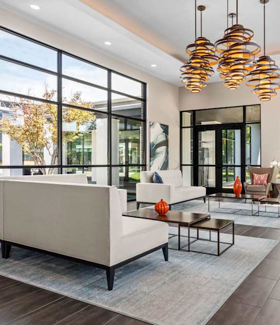 A modern living room with a large white sofa and a glass door.