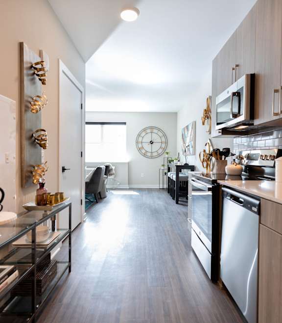 A modern kitchen with a long counter and a clock on the wall at The Nines Apartment Homes Apartments, Allentown, PA, 18101