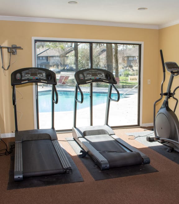the gym has a view of the swimming pool
